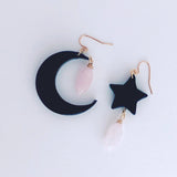 Black moon and star polymer clay earrings with rose quartz crystals. Perfect for an elegant and witchy look.