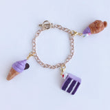 This adorable charm of a delicious ube soft serve ice cream served in a taiyaki cone handmade with polymer clay, hand painted with acrylic paint, and coated in resin. Made to last! This charm can be used on a charm bracelet, necklace chain, or as a keychain on bag zipper to give your outfit a pop of sugar to show your sweet side.